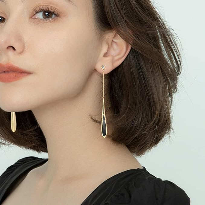 Woman wearing gold earrings with a plain background