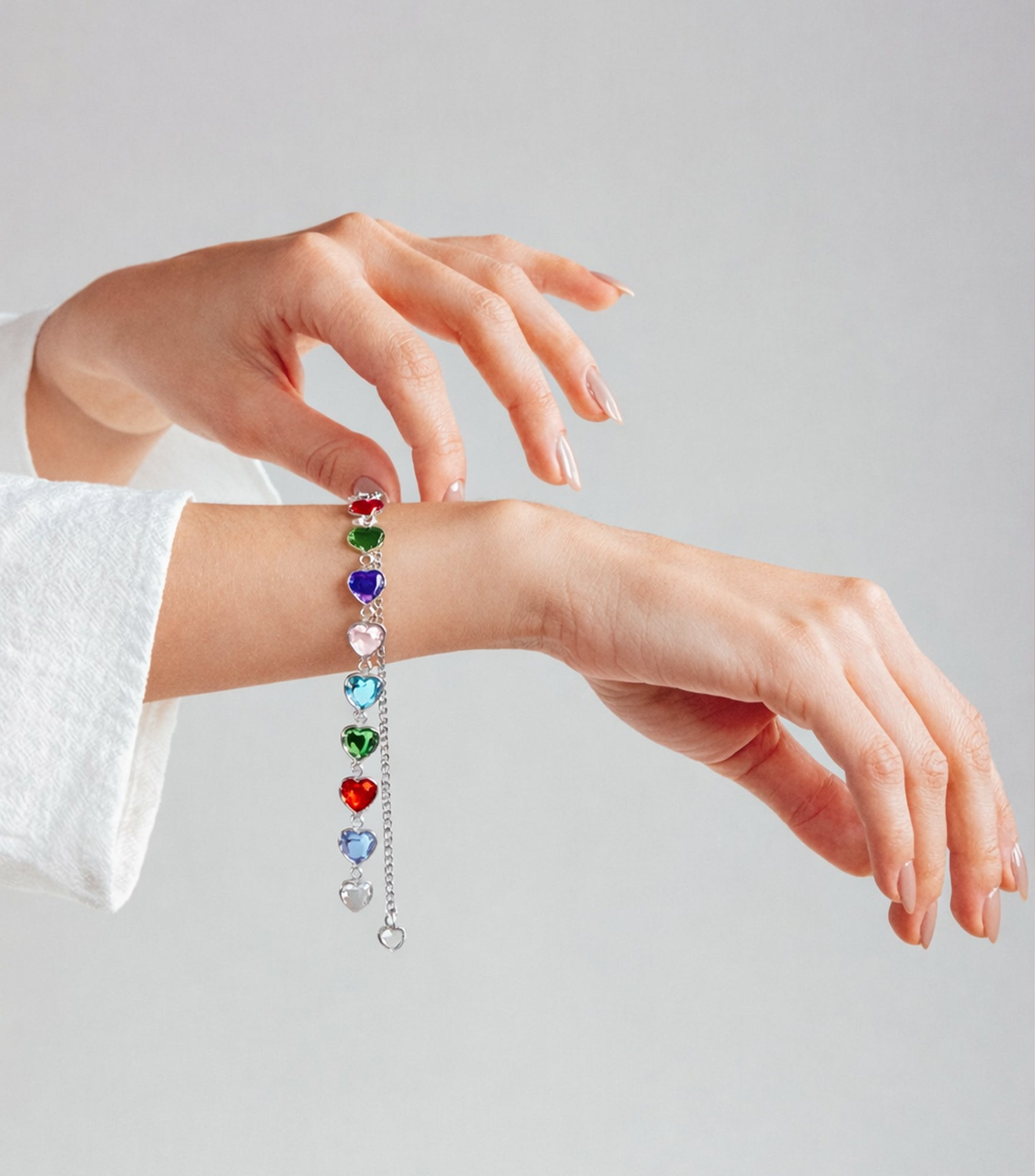 Bracelet with colorful gemstones on a wrist against a plain background