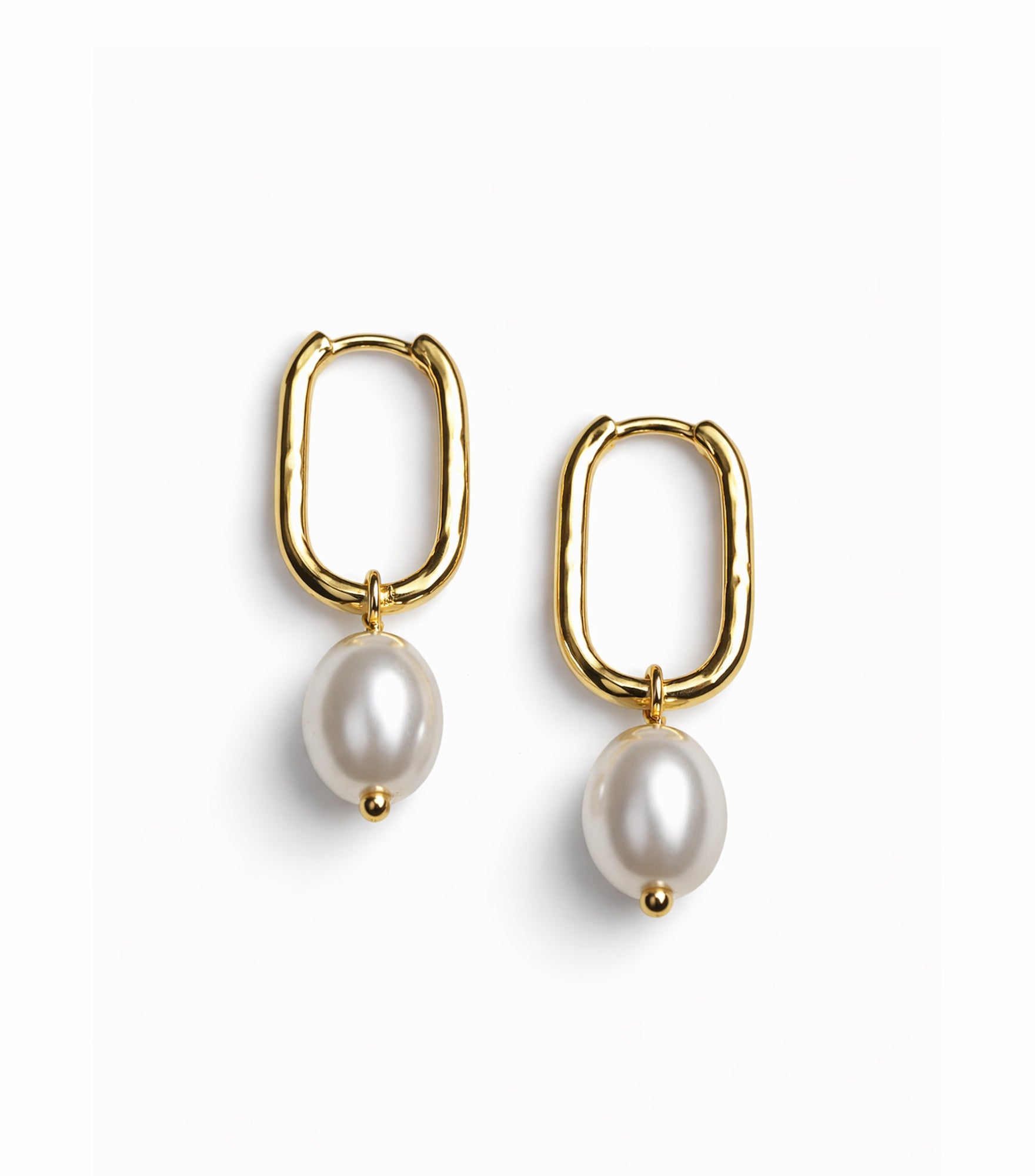Gold hoop earrings with pearl drops on a white background