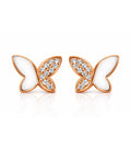 Butterfly-shaped earrings with rose gold frames and white centers on a white background