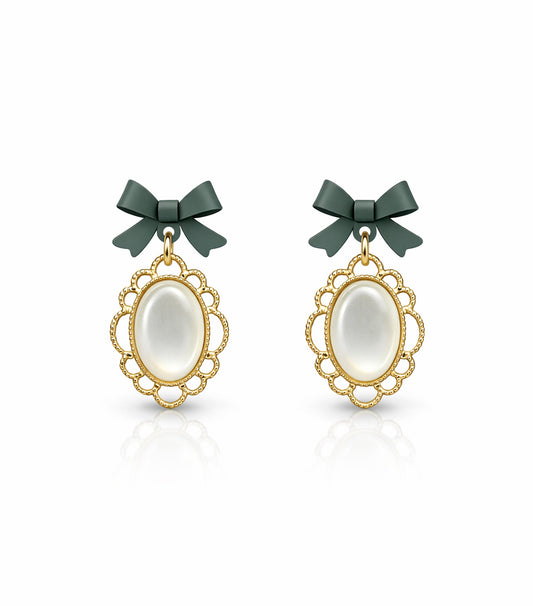 Pair of earrings with gold frames, white stones, and green bows on a white background