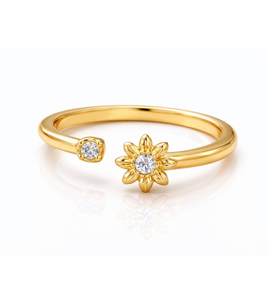 Gold ring with a flower-shaped design and gemstone on a white background
