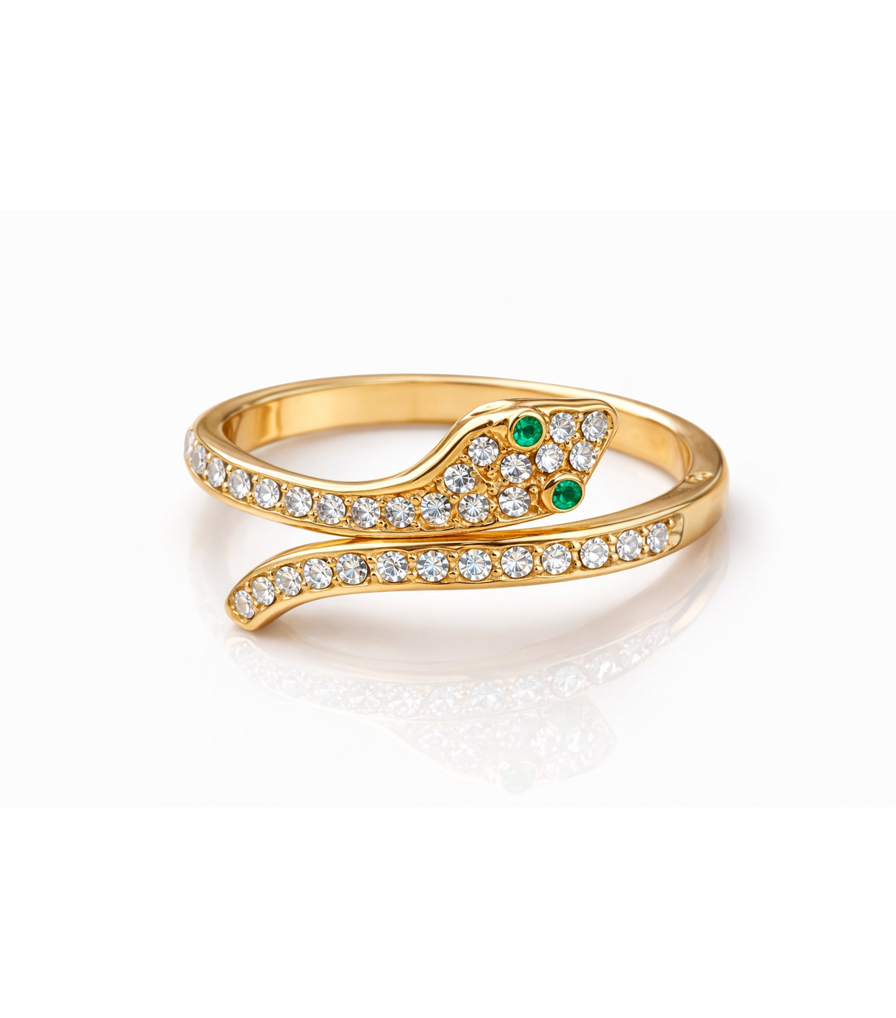 Gold snake-shaped ring with emerald eyes and clear gemstones on a white background


